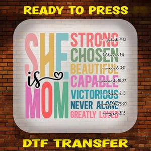 May include: A colourful design with the words "SHE is MOM" and a heart symbol. The words "STRONG, CHOSEN, BEAUTIFUL, CAPABLE, VICTORIOUS, NEVER ALONE, GREATLY LOVED" are stacked vertically with bible verses next to each word. The design is on a white background and says "READY TO PRESS" and "DTF TRANSFER" at the top and bottom.