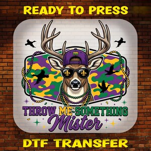 May include: A graphic featuring a deer wearing sunglasses, a purple cap, and a beaded necklace. The deer is set against a background with a purple, green, and yellow camouflage pattern. The text "THROW ME SOMETHING MISTER" is displayed in purple.