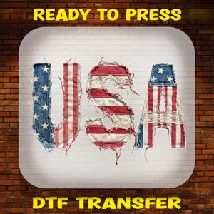May include: A DTF transfer featuring the letters USA styled with a red, white, and blue American flag pattern. The letters have frayed edges and a textured appearance. The text READY TO PRESS and DTF TRANSFER is visible at the top and bottom.