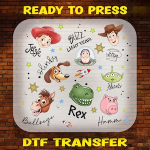 May include: A DTF transfer sheet featuring cartoon illustrations of Toy Story characters including Jessie, Buzz Lightyear, Woody, Slinky Dog, Aliens, Bullseye, Rex, and Hamm, with their names written in black script and small colorful stars.