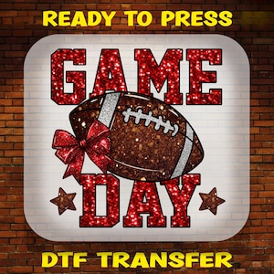 May include: A heat transfer design featuring the text READY TO PRESS at the top and DTF TRANSFER at the bottom. The center displays a brown glitter football with a red glitter bow and the words GAME DAY in large red glitter block letters.