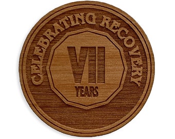Puede incluir: Una moneda redonda de madera con el texto "Celebrating Recovery VII Years" grabado en ella.