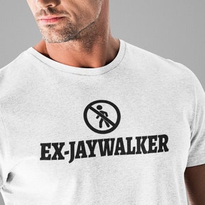 May include: White t-shirt with a black graphic of a no jaywalking sign and the text "EX-JAYWALKER".