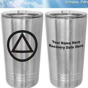 May include: Two stainless steel tumblers with a black triangle symbol on one and the text "Your Name Here Recovery Date Here" on the other. The tumblers are on a white background with a blue sky and clouds. The text "WoodenUrecover.com" is at the top of the image. The text "Unique, Personalized 12 Step Recovery Gifts" is below the website address. The text "NEW COLORS!" is on the right side of the image. The text "Precision Laser Engraving!" is below the "NEW COLORS!" text. The text "Available in 15 Colors!" is below the "Precision Laser Engraving!" text. The text "FREE Personalization!" is below the "Available in 15 Colors!" text. The text "Browse our shop for additional styles and design ideas!" is below the "FREE Personalization!" text. The text "WoodenUrecover.com" is at the bottom of the image.