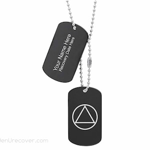 May include: Two black metal dog tags on a silver chain. The top tag has the text "Your Name Here Recovery Date Here". The bottom tag has a white triangle with a circle inside.