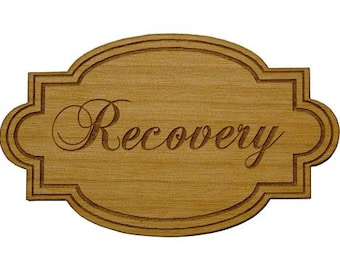 Puede incluir: Un letrero de madera con un borde decorativo y la palabra "Recuperación" grabada en una fuente cursiva.