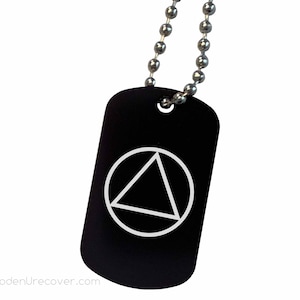 May include: Black metal dog tag with a white circle and triangle symbol. The tag is attached to a silver chain.