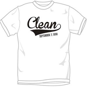 May include: White t-shirt with black text that reads "Clean" with a black baseball-style arc underneath and the date "September 7, 1998" underneath the arc.