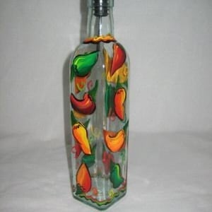 Puede incluir: Una botella de vidrio transparente con un pico de vertido de metal y un diseño pintado a mano de pimientos rojos, naranjas y verdes. La botella es perfecta para almacenar y dispensar aceite de oliva o vinagre.