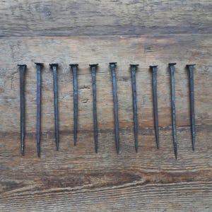 Set aus 5 handgeschmiedeten 15 cm langen Nägeln Alte, handgefertigte Schmiedenägel Seltene quadratische Eisennägel 10 flache Nägel