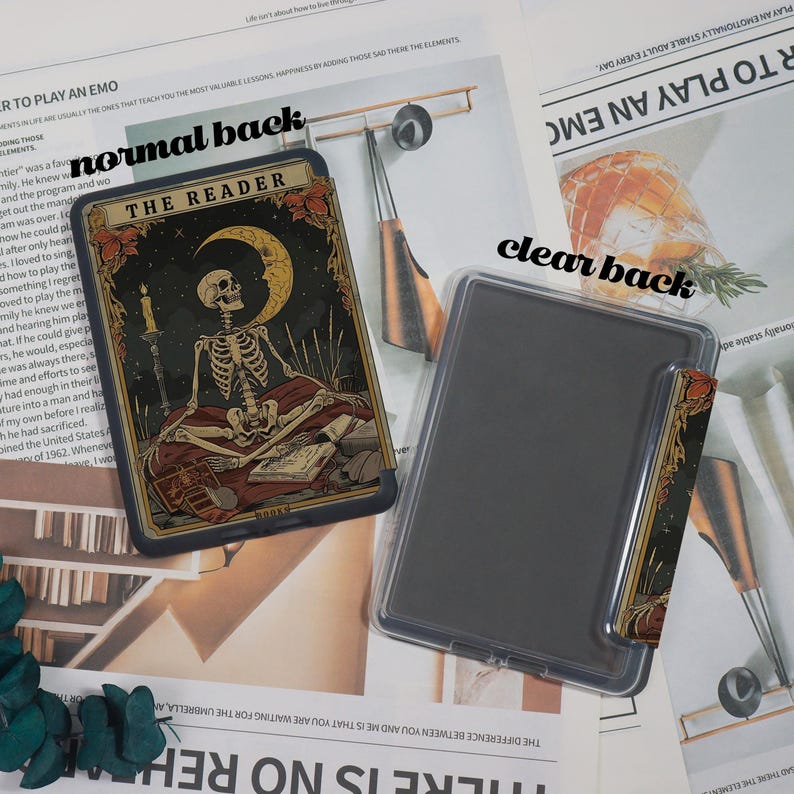 May include: A tarot card featuring a skeleton, a crescent moon, and the text "THE READER" against a dark backdrop. A clear phone case is positioned next to the card, with a small card insert.