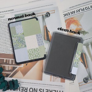 May include: Two tablet cases are displayed. One has a patchwork design in shades of green and white. The other is clear. Both cases have a black border. A matching patterned bookmark is attached to the clear case.