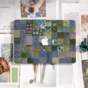 May include: A laptop skin featuring a mosaic tile design in shades of blue, green, and beige. The design incorporates floral, celestial, and geometric patterns. A white Apple logo is centered on the skin.