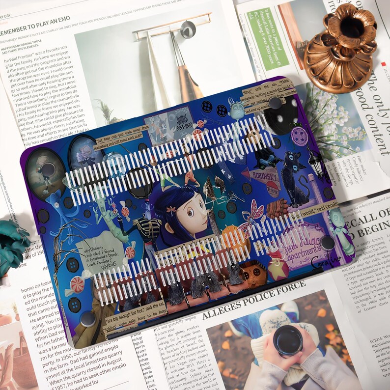 May include: A blue and purple laptop skin featuring a collage of images and text from the movie "Coraline." The design includes characters, buttons, and the text "BORINSKY." The skin has a white, slotted design across the top.