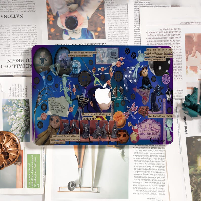 May include: A laptop skin featuring a collage of illustrations and text on a blue background. The design includes characters, buttons, and the text "Be careful what you wish for." An Apple logo is visible.