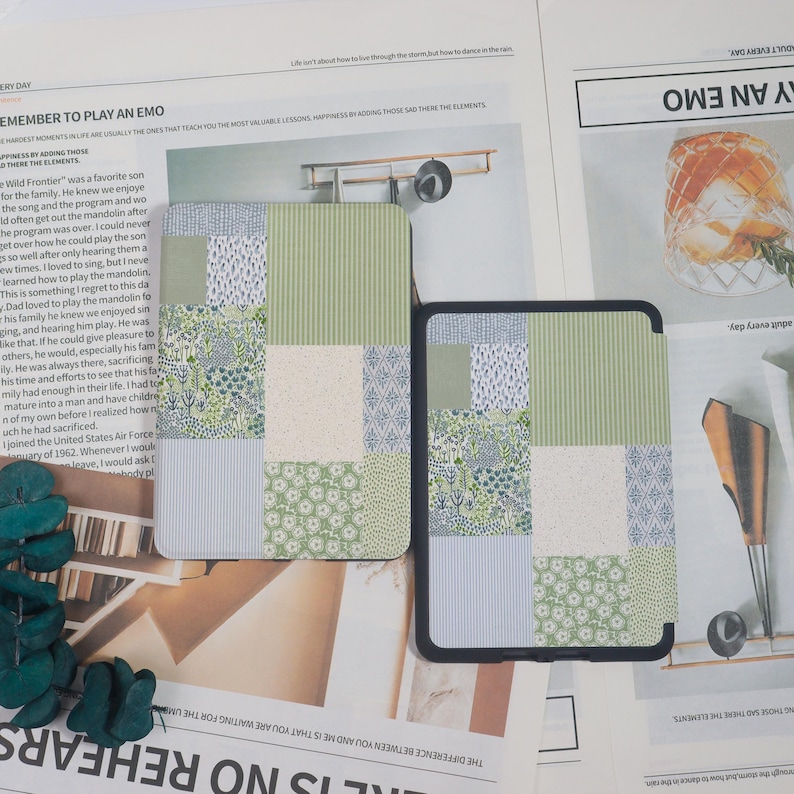 May include: Two patterned tablet cases. One is a patchwork design with green, white, and blue floral and striped patterns. The other case is black with a similar patchwork design. The cases are on a newspaper background.
