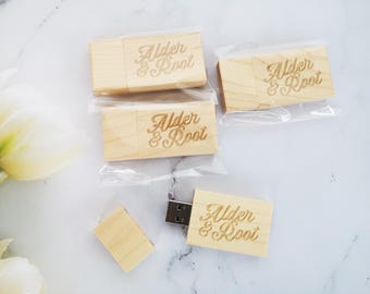 May include: Four wooden USB flash drives with the text "Alder & Root" engraved on them. The flash drives are packaged in clear plastic bags.