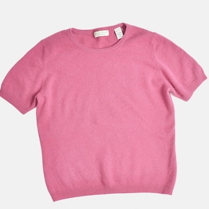 Flat view of a vintage 1990s or Y2K pink cashmere sweater. Fitted, t-shirt style. Short sleeves. Crewneck. Displayed on a dress form with jeans.