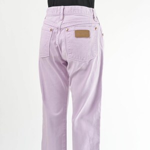 Vintage 90s western style Wrangler jeans. Light purple denim. High waisted. Straight legs. Displayed on dress form with a black t-shirt. Side back view.