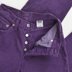 vintage 80s purple Levi's high waisted slim fit tapered leg jeans with button down fly. View of label inside of jeans.