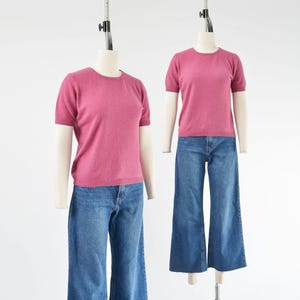 Side by side view of a vintage 1990s or Y2K pink cashmere sweater. Fitted, t-shirt style. Short sleeves. Crewneck. Displayed on a dress form with jeans.