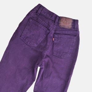 vintage 80s purple Levi's high waisted slim fit tapered leg jeans with button down fly. Close up back view.