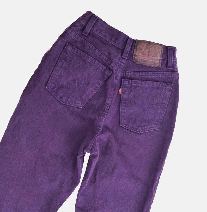 vintage 80s purple Levi's high waisted slim fit tapered leg jeans with button down fly. Close up back view.