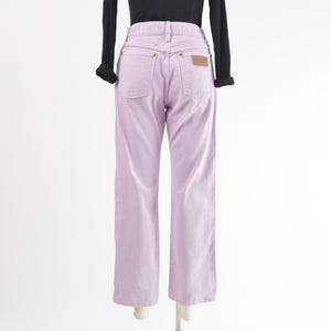 Vintage 90s western style Wrangler jeans. Light purple denim. High waisted. Straight legs. Displayed on dress form with a black t-shirt. Back view.