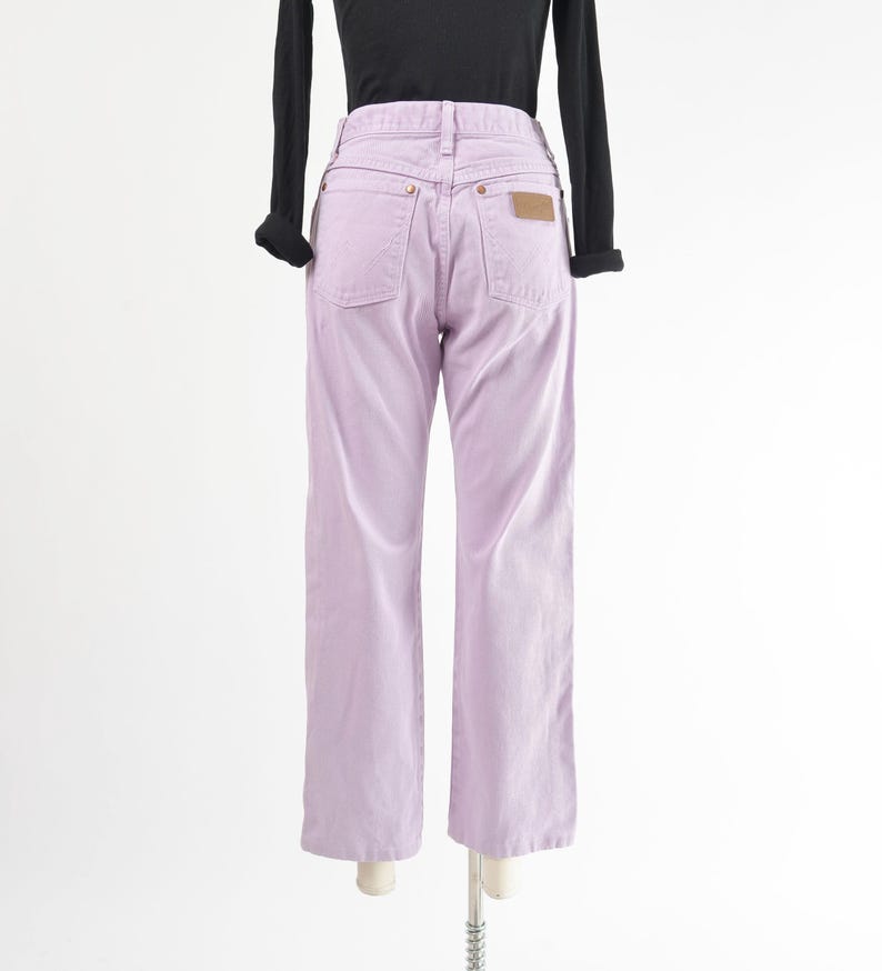 Vintage 90s western style Wrangler jeans. Light purple denim. High waisted. Straight legs. Displayed on dress form with a black t-shirt. Back view.
