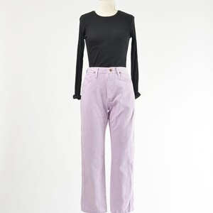 Vintage 90s western style Wrangler jeans. Light purple denim. High waisted. Straight legs. Displayed on dress form with a black t-shirt.