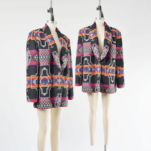Peut inclure: Deux blazers à manches longues présentant une base gris anthracite foncé avec un motif géométrique vibrant dans des tons orange, rouge, bleu et blanc. Chaque blazer possède un revers cranté, une fermeture à un bouton et deux poches.