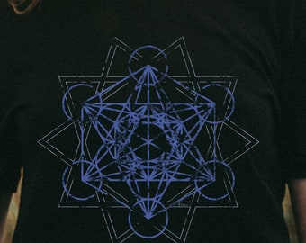 May include: A black t-shirt featuring a geometric design printed on the front. The design is a blue and white mandala with a starburst pattern. The text "Arwen Designs" is printed at the bottom of the shirt.