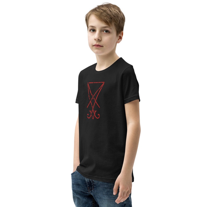 Pode incluir: Camiseta preta de manga curta com um s&iacute;mbolo de pentagrama vermelho na frente.