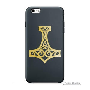 K&ouml;nnte beinhalten: Eine mattschwarze Smartphone-H&uuml;lle mit einer mittigen, goldfarbenen Mjolnir-Hammer-Grafik und komplexen keltischen Knotenmustern. Der Text Arwen Designs ist in einer kleinen, stilisierten Schriftart in der unteren rechten Ecke abgedruckt.