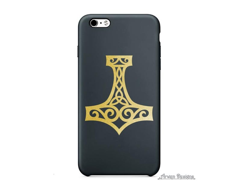 K&ouml;nnte beinhalten: Eine mattschwarze Smartphone-H&uuml;lle mit einer mittigen, goldfarbenen Mjolnir-Hammer-Grafik und komplexen keltischen Knotenmustern. Der Text Arwen Designs ist in einer kleinen, stilisierten Schriftart in der unteren rechten Ecke abgedruckt.