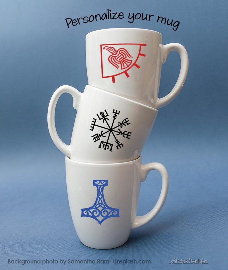 K&ouml;nnte beinhalten: Drei wei&szlig; gestapelte Keramikbecher. Der oberste Becher zeigt eine rote Rabengrafik, der mittlere Becher ein schwarzes Vegvisir-Symbol und der untere Becher ein blaues Mjolnir-Design. Der Text Personalize your mug steht oben im Bild.