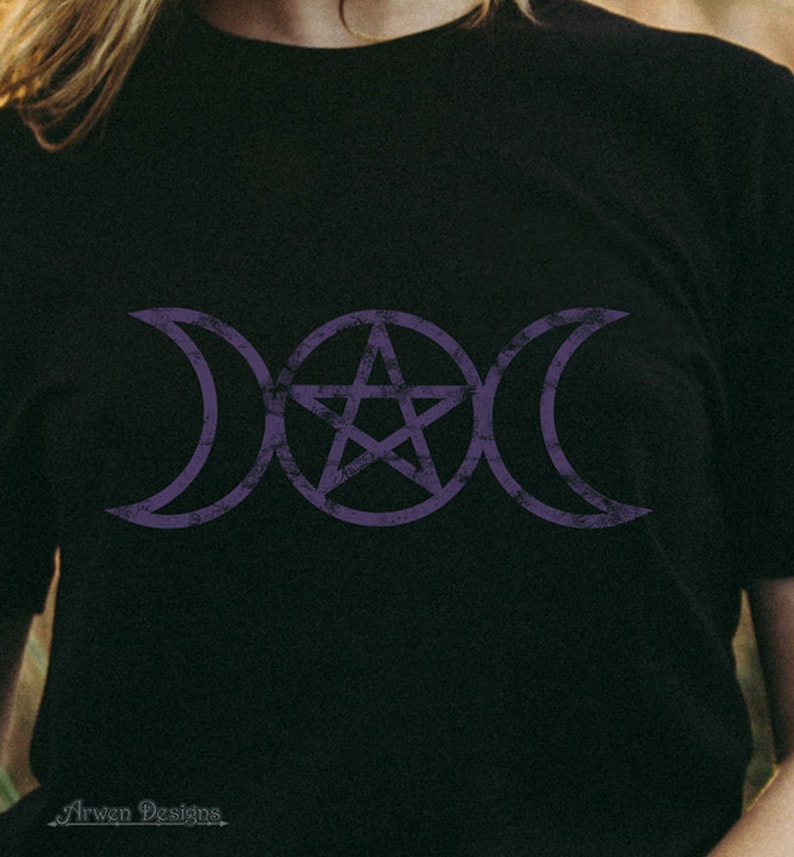 May include: A black t-shirt with a purple triple moon and pentagram symbol. The symbol is a popular symbol in Wiccan and pagan traditions.