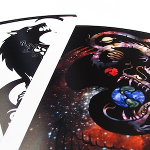 May include: Two black and white illustrations on white cardstock. The left illustration is a wolf howling at the moon. The right illustration is a dragon with a galaxy background.