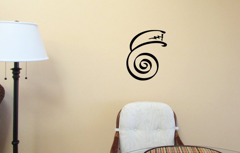 K&ouml;nnte beinhalten: Ein schwarzer und wei&szlig;er Wandaufkleber mit einem Spiraldesign, der eine Spiralform mit einem geschwungenen Schwanz zeigt. Der Aufkleber ist auf einer hellbeigen Wand in einem Raum mit einem wei&szlig;en Stuhl und einer Lampe angebracht.