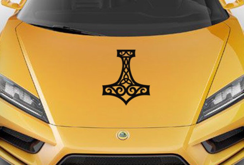K&ouml;nnte beinhalten: Ein schwarzer Vinyl-Aufkleber mit einem stilisierten Mjolnir-Hammer-Design und komplexen keltischen Knotenmustern, der mittig auf einer leuchtend gelben Motorhaube angebracht ist. Die Grafik ist einfarbig schwarz und zeigt symmetrische Schn&ouml;rkel.