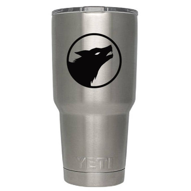 K&ouml;nnte beinhalten: Ein Yeti-Becher aus Edelstahl mit einer schwarzen Wolfssilhouette in einem Kreis auf der Seite. Der Becher hat das Wort "YETI" auf dem Boden eingepr&auml;gt.