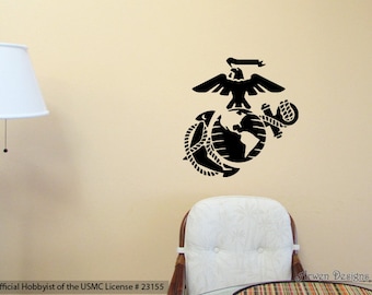 Könnte beinhalten: Schwarz-weißes Abziehbild des Emblems des United States Marine Corps. Das Emblem zeigt einen Adler, einen Globus und einen Anker. Das Abziehbild befindet sich an einer hellbeigen Wand. "Official Hobbyist of the USMC License # 23155" ist unterhalb des Emblems gedruckt.