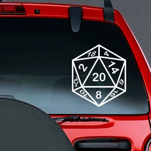 May include: A white vinyl decal of a twenty-sided die, or d20, featuring clear black outlines and numbers including 20, 18, 4, 14, 6, 16, 8, 10, 12, and 2, applied to the rear window of a red vehicle. The geometric shape is centred on the glass.