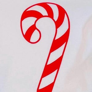 Könnte beinhalten: Ein weißer Hintergrund mit einem großen rot-weiß gestreiften Zuckerstangen-Design. Die Zuckerstange ist ein klassisches Weihnachtssymbol mit einem gebogenen Oberteil und einem langen, geraden Körper.