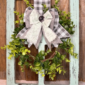 Rustic window frame with wreath and ribbon decor
