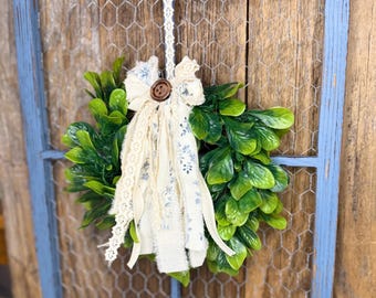 Moldura de janela rústica com tela de galinheiro, guirlanda e decoração de fita.