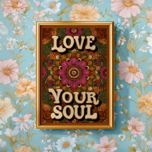 Puede incluir: Una impresi&oacute;n art&iacute;stica enmarcada con las palabras "LOVE YOUR SOUL" en una fuente retro. La obra de arte presenta un dise&ntilde;o de mandala floral en tonos de rosa, naranja y verde. El marco es dorado y el fondo es un papel pintado floral.