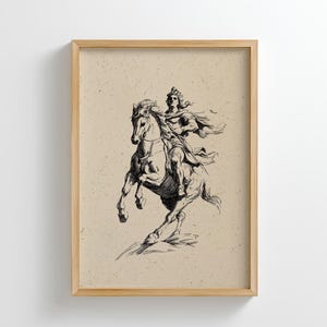 Puede incluir: Ilustración en blanco y negro enmarcada de una persona a caballo. El jinete, con capa y casco, se representa en una pose dinámica, con el caballo encabritado. La obra de arte está sobre un fondo beige, dentro de un marco de madera.