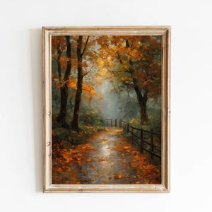 Puede incluir: Pintura enmarcada de un paisaje otoñal. El camino está bordeado de árboles con hojas doradas, y el suelo está cubierto de hojas caídas. Una valla de madera bordea el camino, con un cielo azul brumoso encima.