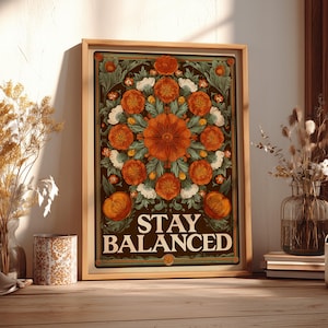 May include: A framed art print featuring a floral design with orange and white flowers on a dark brown background. The text "STAY BALANCED" is displayed in white. The artwork is in a wooden frame, creating a vintage aesthetic.